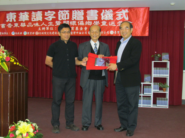昱華基金會董事長王慶豐(中)代表贈書給東華大學,右為校長吳茂昆、左為吳明益副教授