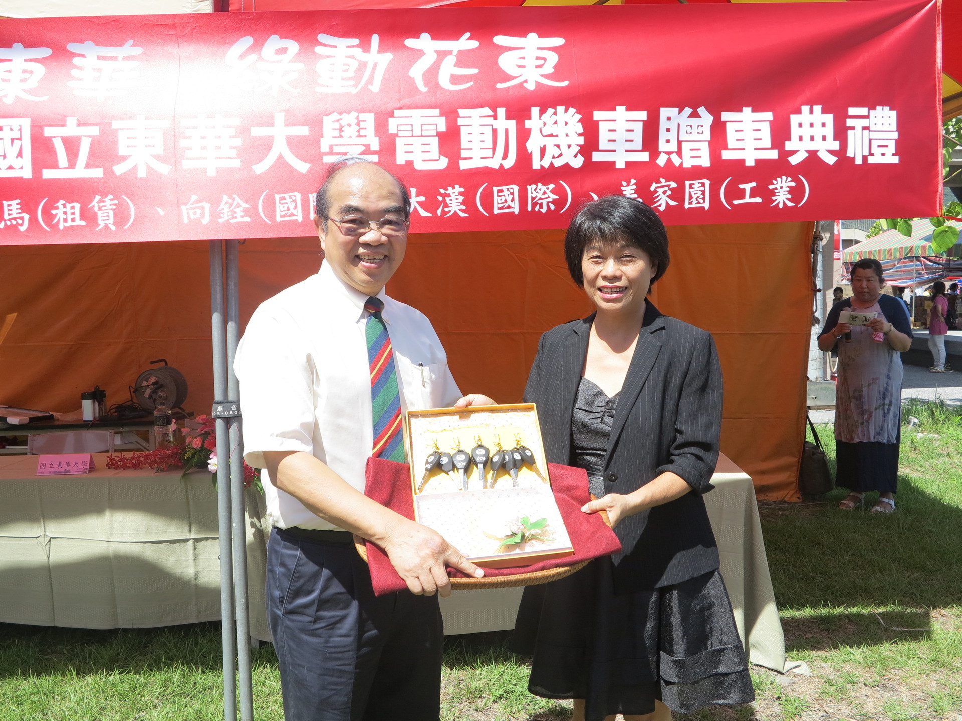 有量科技董事長劉向春（右）代表花東綠能聯盟贈送5把車鑰匙給校長吳茂昆（左）