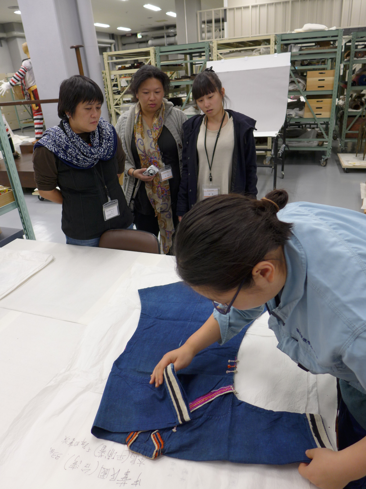團隊成員（左起謝若蘭、尤美茜、郭名茵）於國立民族學博物館典藏室近距離研究平埔族群衣物織繡紋路。