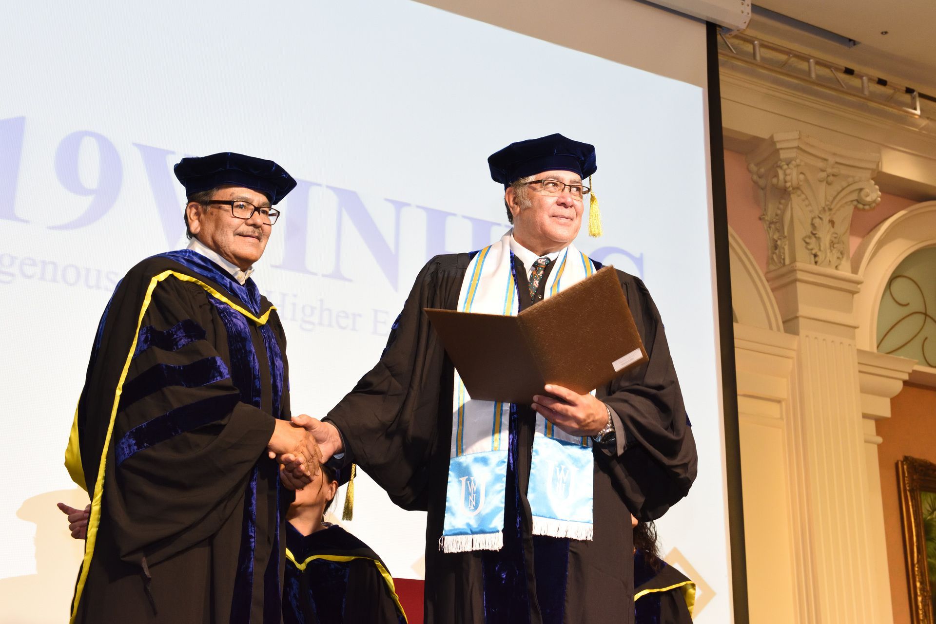 WINHEC 共同主席Dr. Elmer Guy （圖左）頒發榮譽領袖獎項給前任共同主席紐西蘭籍的Dr. Hohaia Collier （圖右）。Dr. Collier 於今年接任世界原住民族大學校長
